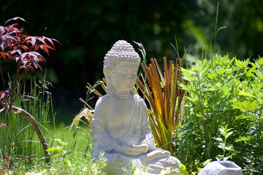 Buddha statue surrounded by vibrant green foliage, creating a peaceful garden ambiance.